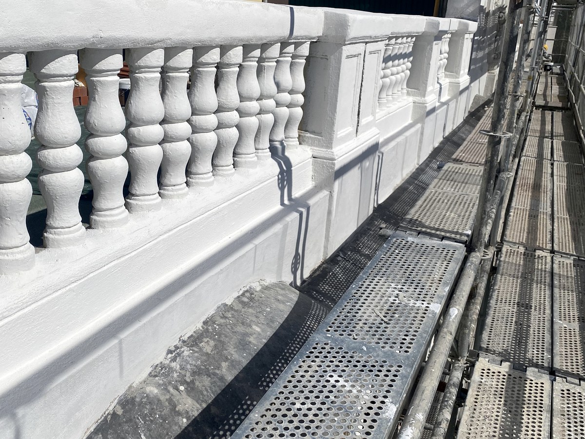 Restauración de cornisa con balaustres clásicos en edificio madrileño